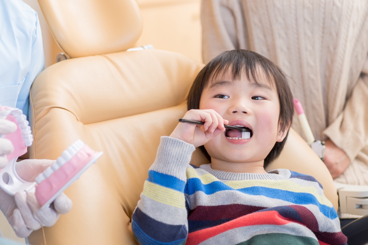 歯科医院で歯磨きの指導を受ける子供